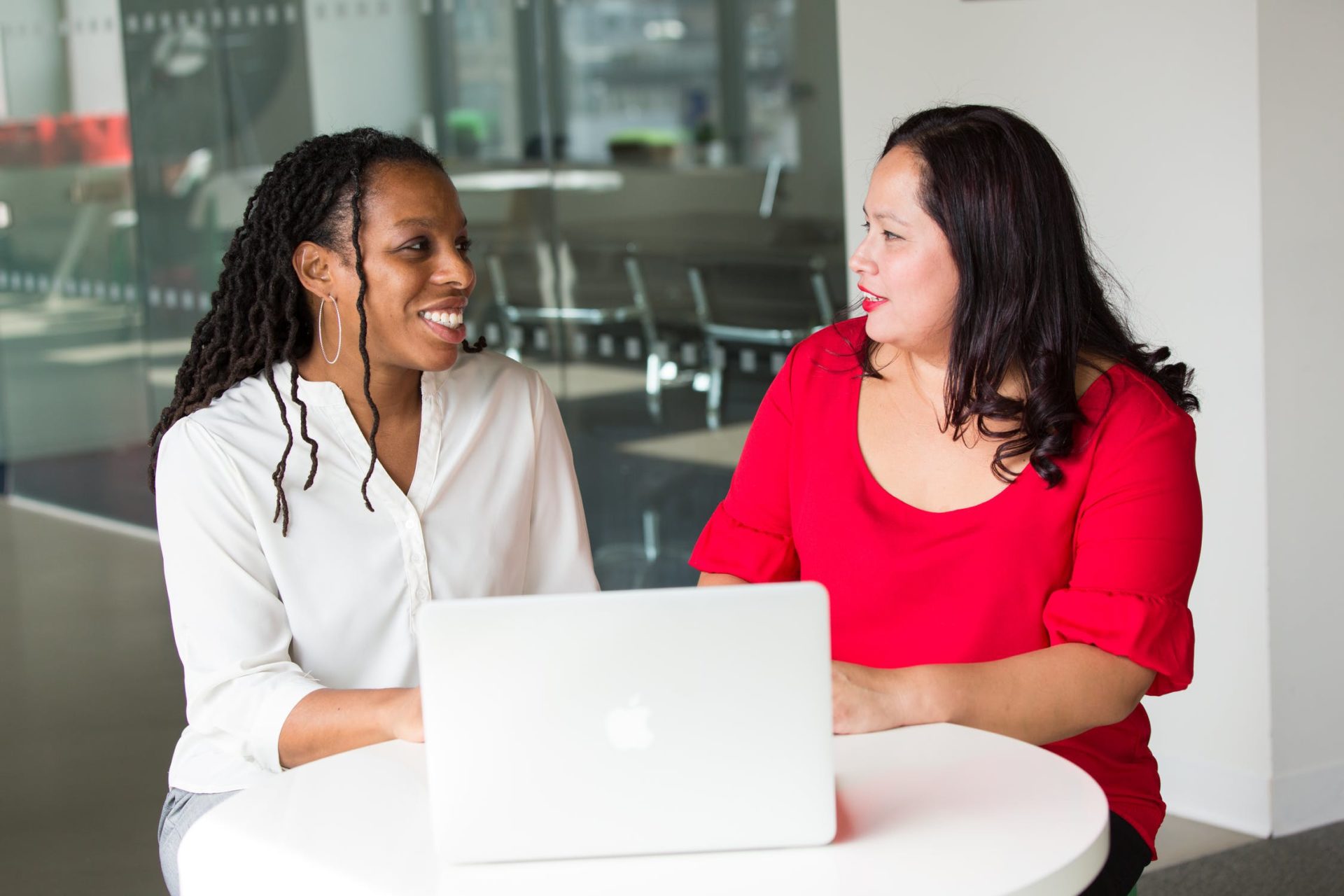 two women talking with laptop